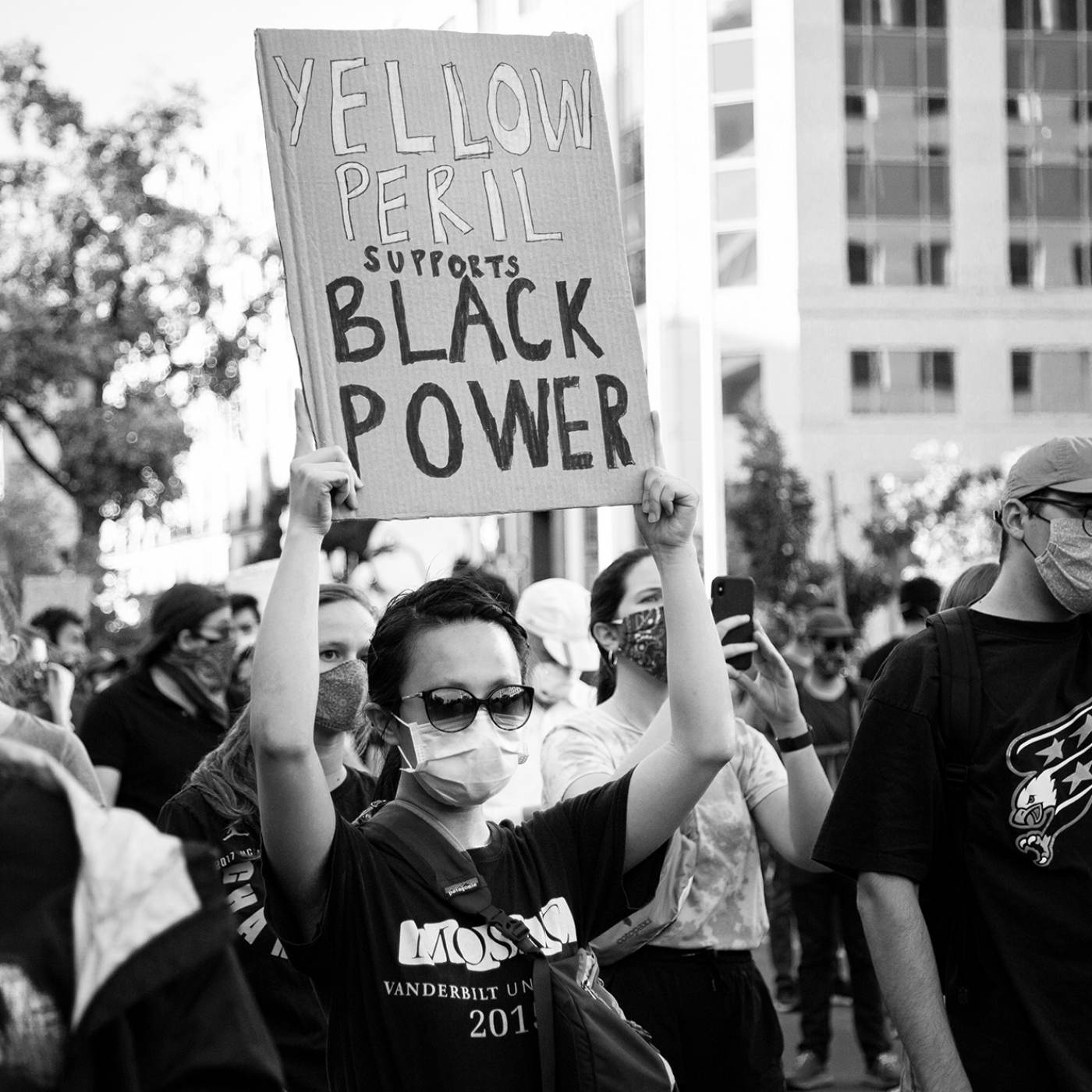 Asians for Black Lives: An unnamed woman at a Black Lives Matter rally near the White House, Washington DC. She is holding a sign that says “Yellow Peril Supports Black Power.”  Photograph by Mengyu Dong