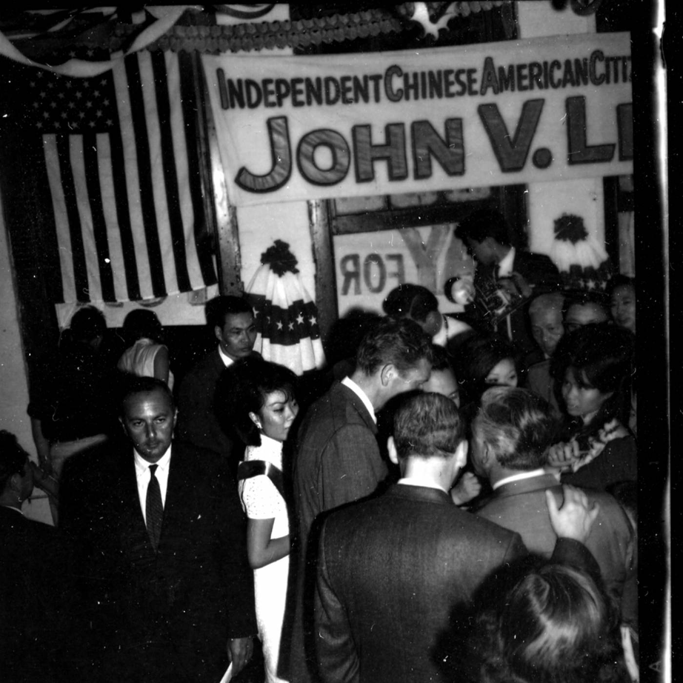 2000.020.041 Crowd of people gathered under an American flag and banner that reads "Independent Chinese American Citizens of New York City for John V. Lindsay." 人群聚集在美国国旗和写着 “纽约市独立华裔美国公民支持约翰·V·林赛（John V. Lindsay）”的横幅下。
