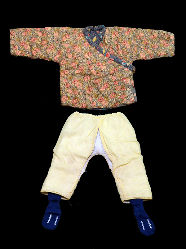 2007.053.001 A digital image of the outfit an adopted child was wearing when she was adopted from China - a quilted top, split pants and Baby Gap socks. Courtesy of Alisa Herman-Liu and Tony Liu, Museum of Chinese in America (MOCA) Adoptee Collection
数码照片，一个被收养的孩子从中国领养时所穿的服装 ——绗缝上衣、开衩裤和 Baby Gap 袜子。Alisa Herman-Liu 和 Tony Liu捐赠， 美国华人博物馆 (MOCA) 收养档案馆藏