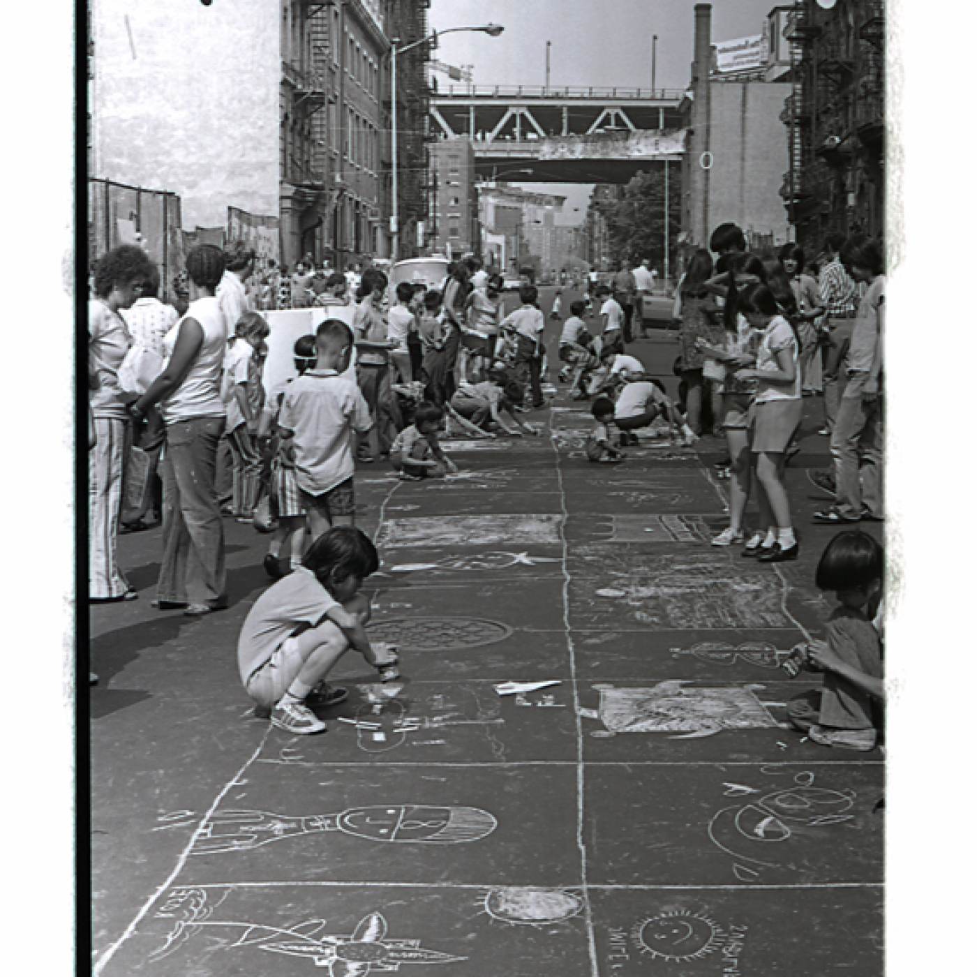 2015.019.062 Children making chalk drawings on the blacktop of Henry Street, July, 1972. Courtesy of Henry Chu, Museum of Chinese in America (MOCA) Collection. 1972 年 7 月，孩子们在亨利街的柏油路上画粉笔画。图片由Henry Chu 捐赠，美国华人博物馆 (MOCA) 馆藏。