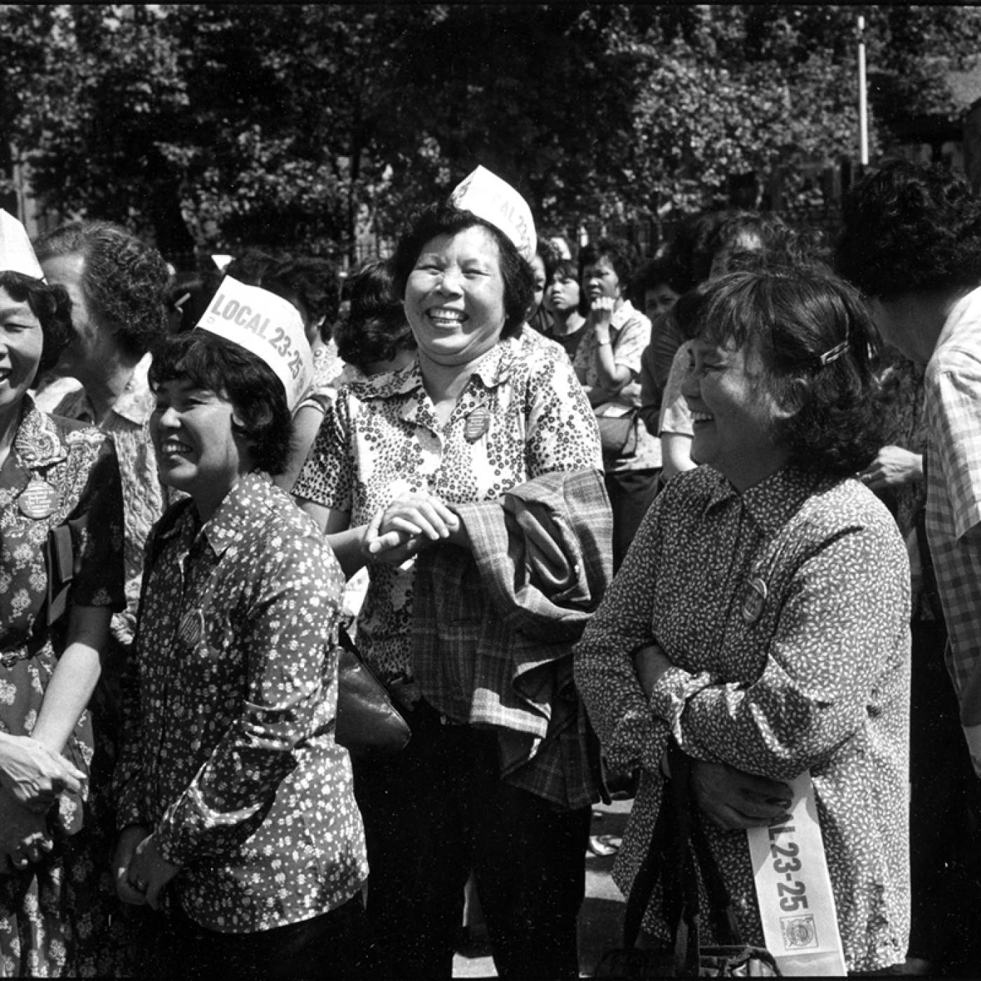 2005.009.002 Women at garment workers' strike and rally at Columbus Park, Chinatown. Photograph taken by Paul Calhoun, 1982. Museum of Chinese in America (MOCA) Collection. 唐人街哥伦布公园服装工人罢工和集会的妇女。照片由 Paul Calhoun 拍摄，1982 年。美国华人博物馆 (MOCA) 馆藏。