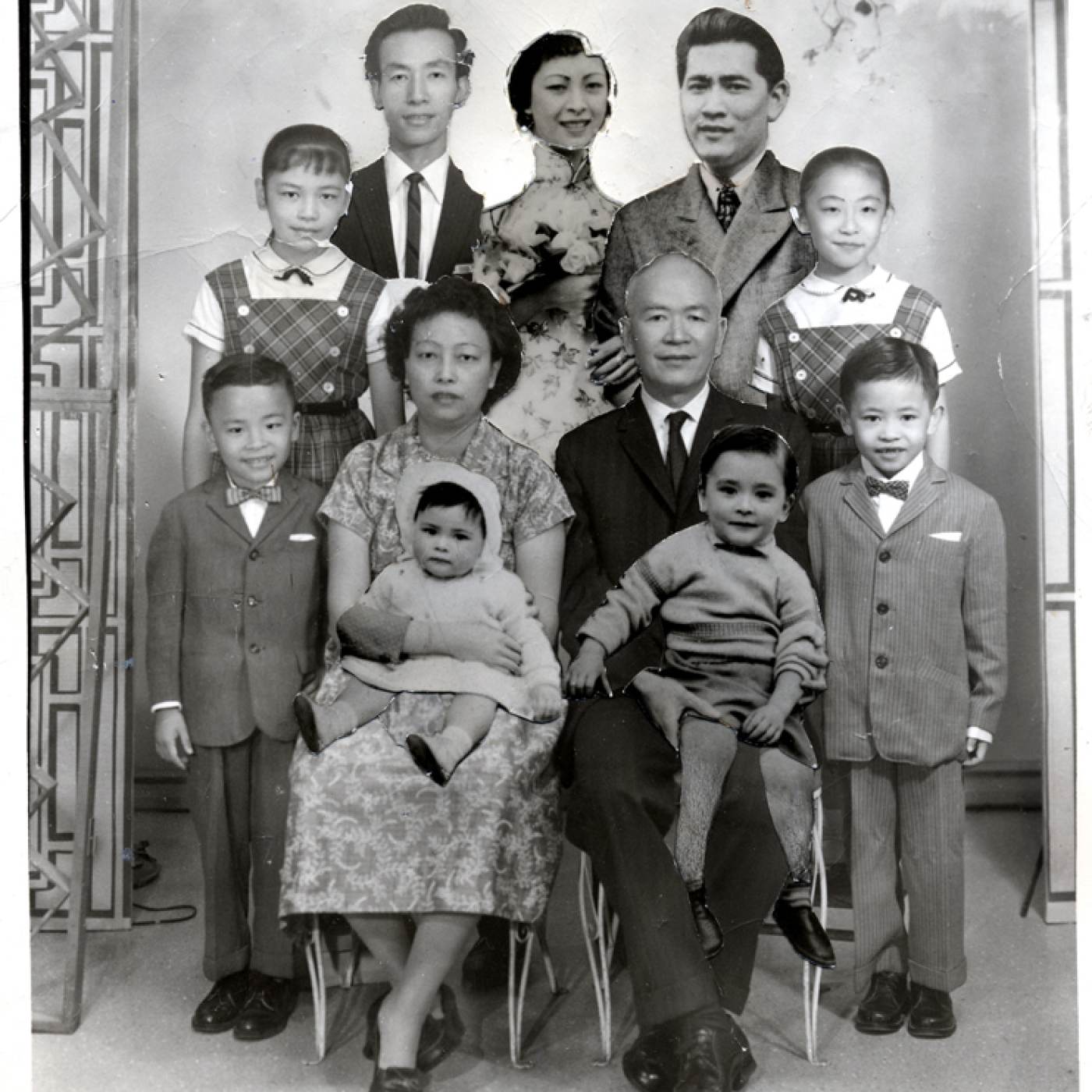 2004.005.055 A composite family portrait of the Low Family, held together with masking tape. The base photograph was taken ca. 1961 with additional photographs affixed at an unknown date. Lin S. Low is the elderly man in the center. His wife, Kow Gin Mark, is seated next to him. Clockwise from left are: Mildred Y. Lee, daughter; Gim, son; Moo Gee, daughter; Stanley Wong, son-in-law (Moo Gee's husband); Marilyn, daughter; Kam F. (Johnny), son; David, grandson; Pauline, granddaughter; Kam C. (Danny), son. Museum of Chinese in America (MOCA) Collection. 
2004.005.055 Low Family 的复合全家福，用胶带固定在一起。基础照片拍摄于大约 1961 年，上面附有未知日期的附加照片。 Lin S. Low 是中间的老人。他的妻子 Kow Gin Mark 坐在他旁边。左起顺时针为：Mildred Y. Lee，女儿；吉姆（Gim），儿子；穆吉（Moo Gee），女儿； Stanley Wong，女婿（穆吉的丈夫）；玛丽莲（Marilyn），女儿； Kam F. (Johnny)，儿子；大卫（David），孙子；宝琳（Pauline,），孙女； Kam C. (Danny)，儿子。美国华人博物馆（MOCA）馆藏。