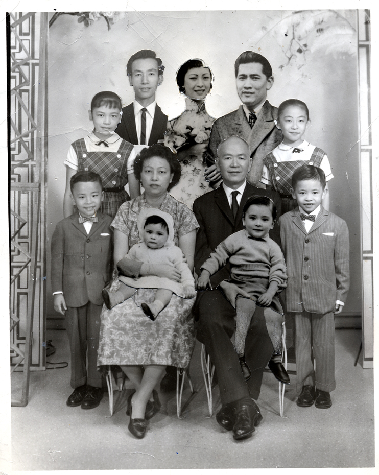  2004.005.055 A composite family portrait of the Low Family, held together with masking tape. The base photograph was taken ca. 1961 with additional photographs affixed at an unknown date. Lin S. Low is the elderly man in the center. His wife, Kow Gin Mark, is seated next to him. Clockwise from left are: Mildred Y. Lee, daughter; Gim, son; Moo Gee, daughter; Stanley Wong, son-in-law (Moo Gee's husband); Marilyn, daughter; Kam F. (Johnny), son; David, grandson; Pauline, granddaughter; Kam C. (Danny), son. Museum of Chinese in America (MOCA) Collection. 
2004.005.055 Low Family 的复合全家福，用胶带固定在一起。基础照片拍摄于大约 1961 年，上面附有未知日期的附加照片。 Lin S. Low 是中间的老人。他的妻子 Kow Gin Mark 坐在他旁边。左起顺时针为：Mildred Y. Lee，女儿；吉姆（Gim），儿子；穆吉（Moo Gee），女儿； Stanley Wong，女婿（穆吉的丈夫）；玛丽莲（Marilyn），女儿； Kam F. (Johnny)，儿子；大卫（David），孙子；宝琳（Pauline,），孙女； Kam C. (Danny)，儿子。美国华人博物馆（MOCA）馆藏。