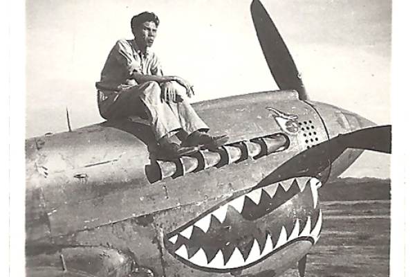 2015.037.005 Kenneth P. Moy sitting on a plane painted with the iconic shark's jaws flown by American Volunteer Group (AVG) fighter pilots, or "Flying Tigers." On the back of the photograph, "China 1944" has been written. Courtesy of Douglas J. Chu, Museum of Chinese in America (MOCA) Collection. 