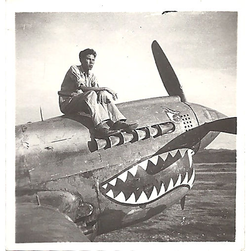 2015.037.005 Kenneth P. Moy sitting on a plane painted with the iconic shark's jaws flown by American Volunteer Group (AVG) fighter pilots, or "Flying Tigers." On the back of the photograph, "China 1944" has been written. Courtesy of Douglas J. Chu, Museum of Chinese in America (MOCA) Collection. 