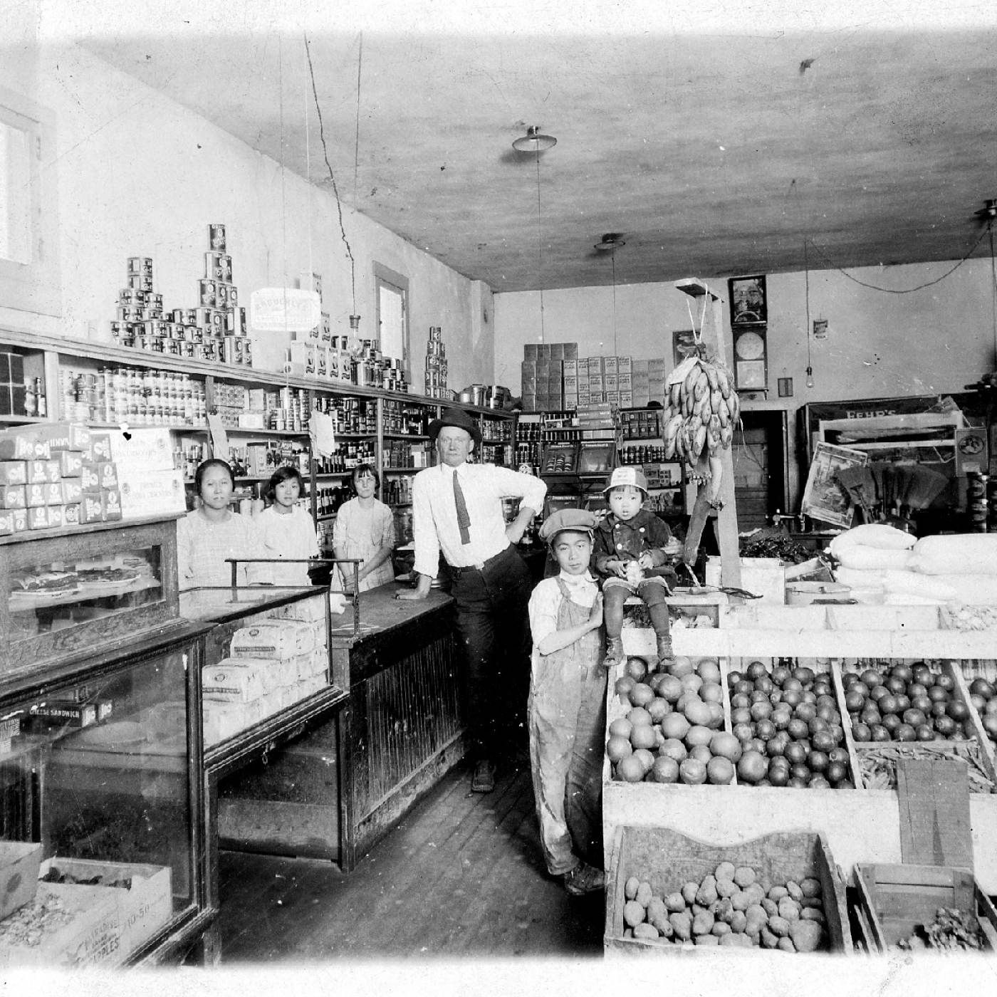 2001.015.009 The Tang family and their family store, Ong Yee Lung Grocery Store, in Arizona in 1922. From left to right are: Mary (Fong Shee Tang), Mabel Tang, Eleanor (friend), salesman, Sing John Tang, and Mae Tang. Courtesy of Lois Tang Leung, Museum of Chinese in America (MOCA) Collection. 1922 年在亚利桑那州的唐氏家族和他们的家族商店，Ong Yee Lung杂货店。从左到右分别是：玛丽（Fong Shee Tang）、Mabel Tang、Eleanor（朋友）、推销员、Sing John Tang 和Mae Tang。由Lois Tang Leung 捐赠，美国华人博物馆 (MOCA) 馆藏。