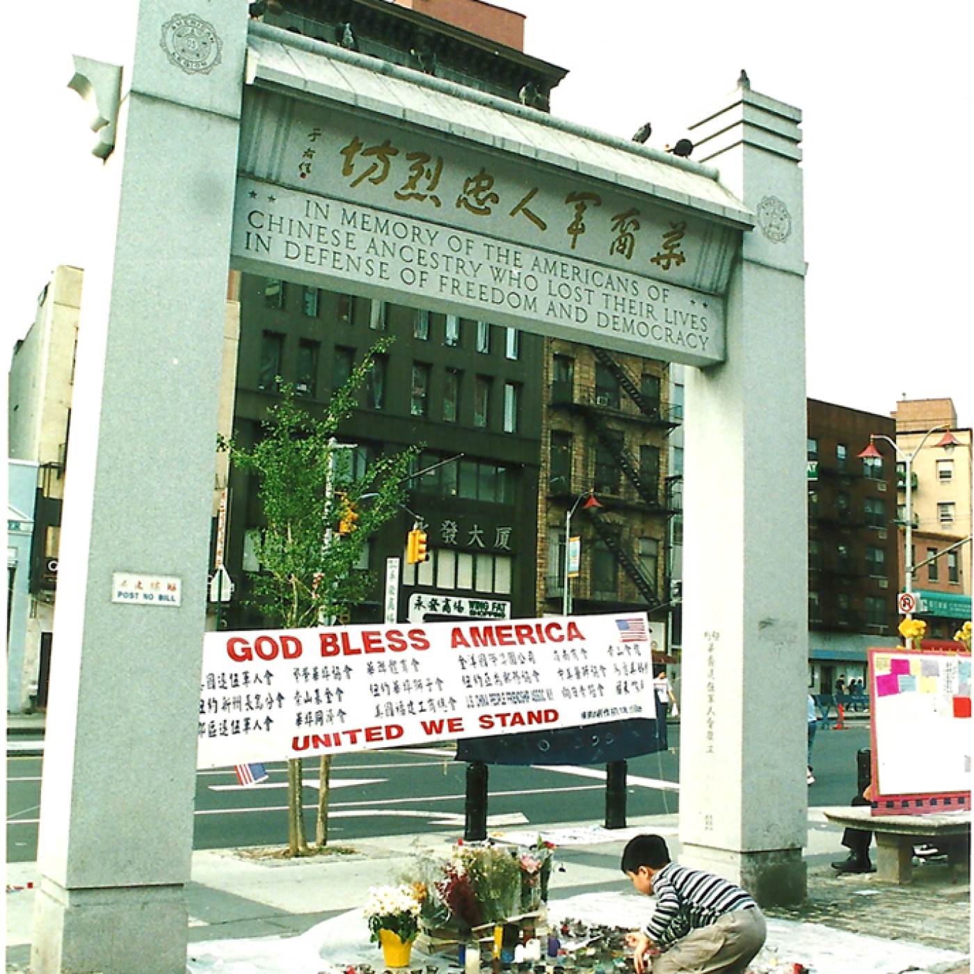 2002.014.003 9/11 纪念馆在且林士果广场劳金纪念拱门下设立，2001年。照片由 Lia Chang 拍摄，美国华人博物馆 (MOCA) 恢复唐人街：9/11 馆藏。
