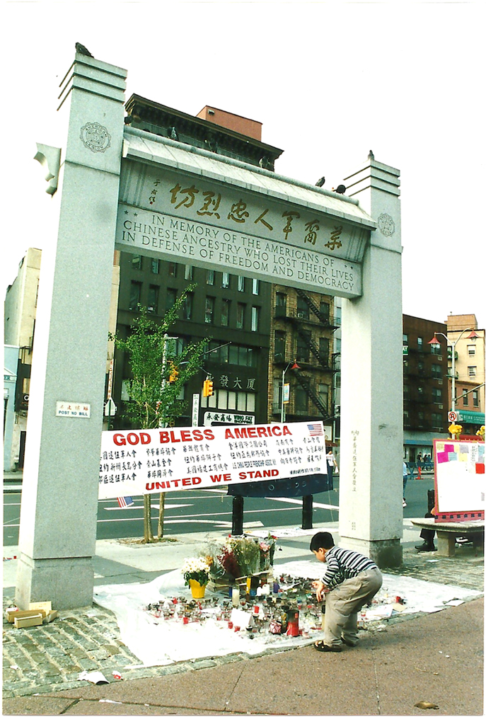 2002.014.003 9/11 纪念馆在且林士果广场劳金纪念拱门下设立，2001年。照片由 Lia Chang 拍摄，美国华人博物馆 (MOCA) 恢复唐人街：9/11 馆藏。
