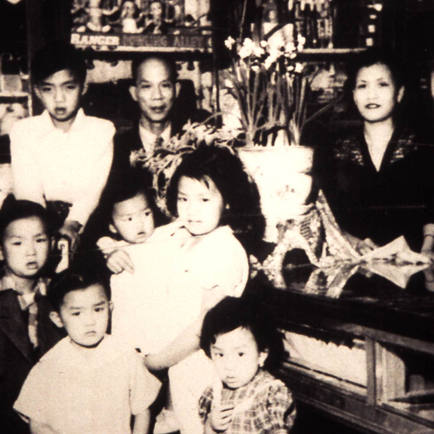 2011.031.003 Don Rodolfo Lau and family in Almacén El Bien Mutuo, 5a. avenida, Guatemala City, early 1950s. First row, left to right: Alberto, Esperanza. Second row, left to right: Armando, Amelia, Gloria. Third row, left to right: Adolfo, don Rodolfo, doña Graciela Chang de Lau. Courtesy of Amelia Lau Carling, Museum of Chinese in America (MOCA) Collection.