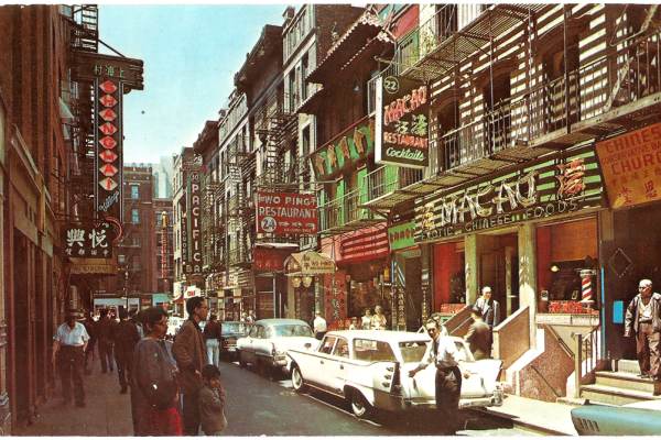 2015.043.336-a This postcard shows a view of Pell Street in 1968 with an assortment of restaurants and places including the Chinese Conservative Baptist Church, Macao Restaurant on 22 Pell, Shanghai Restaurant on 23 Pell, Wo Ping Restaurant on 24 Pell, and Pacific Restaurant on 30 Pell. There are people and now antique automobiles on the streets. Courtesy of Eric Y. Ng, Museum of Chinese in America (MOCA) Collection.
