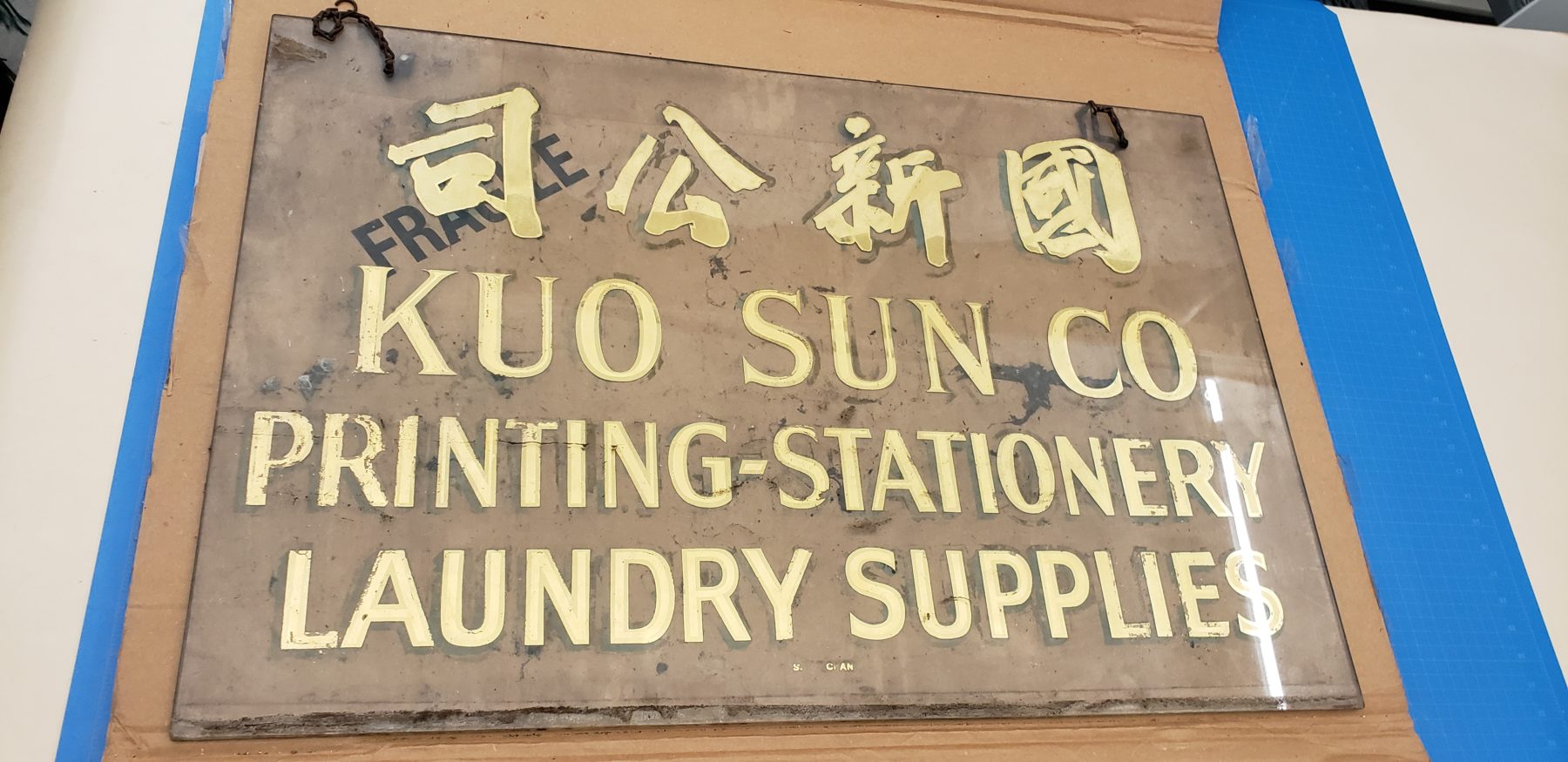 Kuo Sun Co. glass sign. Courtesy of Good Jean Lau. Museum of Chinese in America (MOCA) Collection.