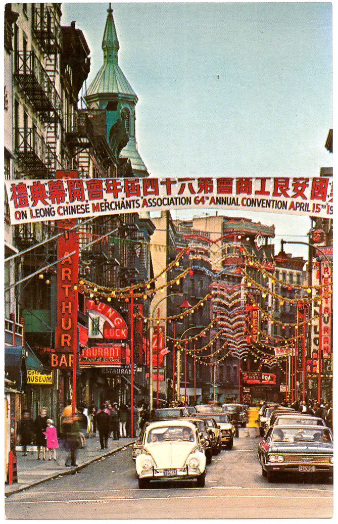 A postcard of Mott Street decorated for the On Leong Chinese Merchants Association 64th Annual Convention with a banner in Chinese and English and lights. The convention took place on April 15, ca. 1960s. Visible business signs include Port Arthur, Chinese Museum, and Tung Luck Restaurant. The Church of Transfiguration is visible in the distance. Courtesy of Eric Y. Ng, Museum of Chinese in America (MOCA) Collection.