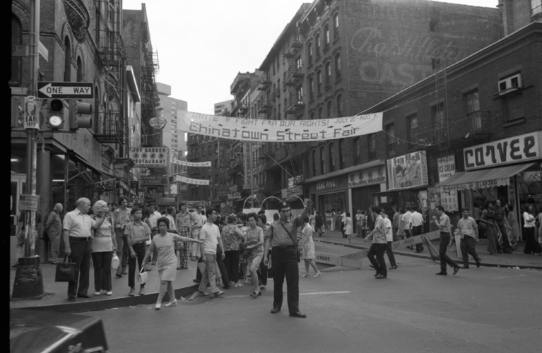"Unite & Fight for Our Rights!" banner promoting the Chinatown Street Fair from July 28th-August 5th, 1973, on Mott Street at the intersection of Bayard. Photograph taken by Emile Bocian, Museum of Chinese in America (MOCA) Collection.